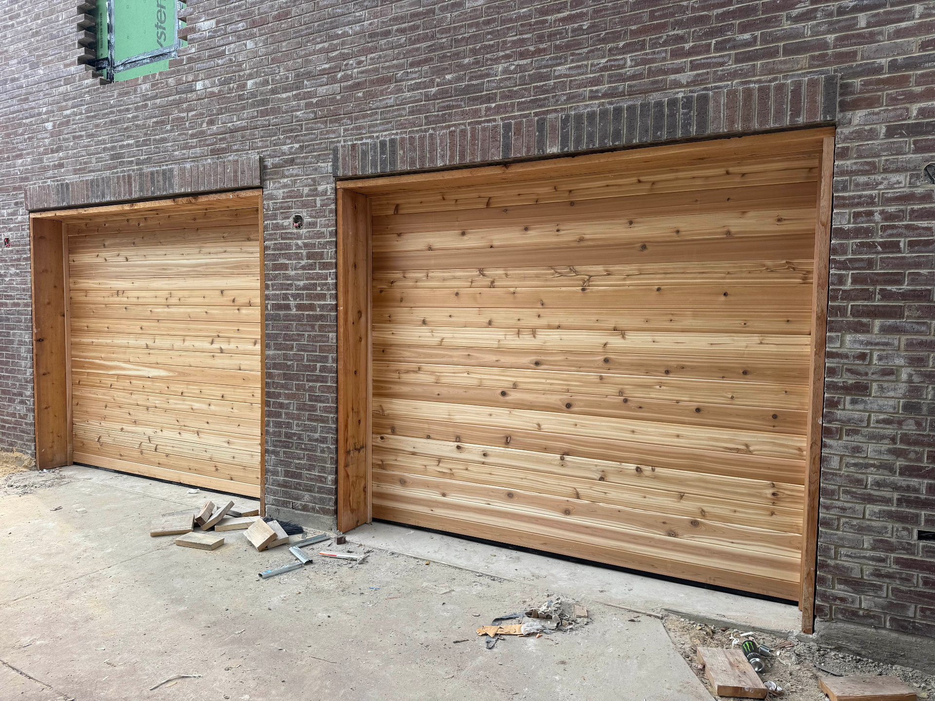 Cedar wood garage doors on a brick facade